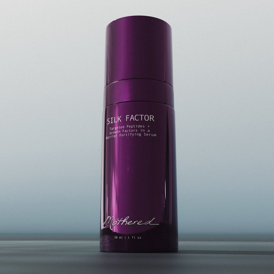 Purple bottle of Silk Factor serum on a gray background